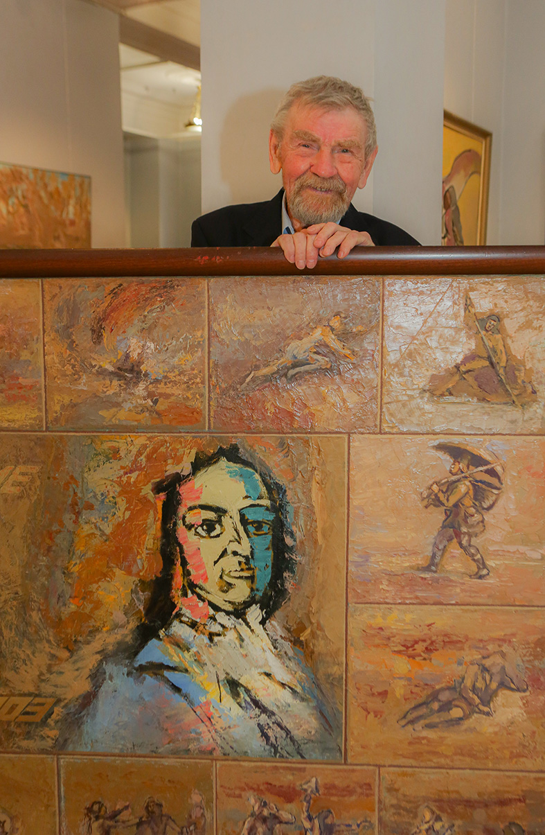 Nikolai Kuzmin at his solo exhibition in December 2024 in Moscow, with his painting, 